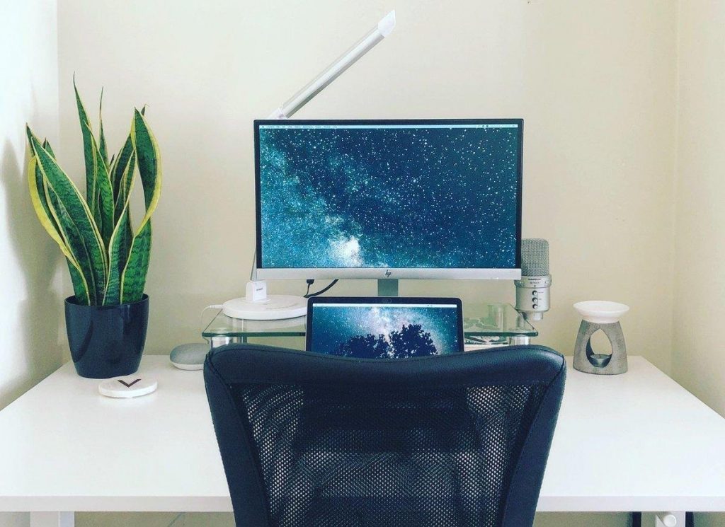 White desk with plant, monitor, laptop and oil burner. - Working from Home Tips